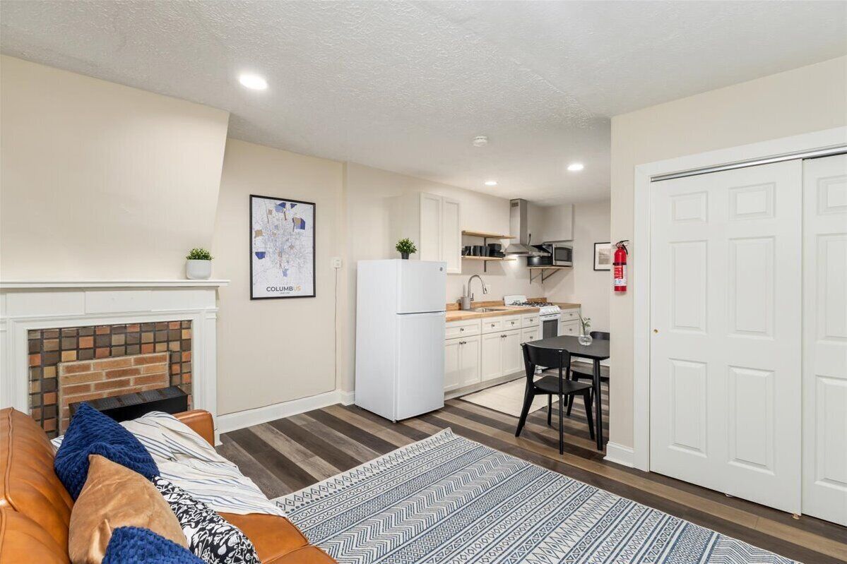 Un espace de vie compact comprenant une kitchenette, un coin repas et une cheminée.