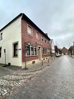 Straßenansicht mit einem Gebäude, auf dem 'Hotel' steht.