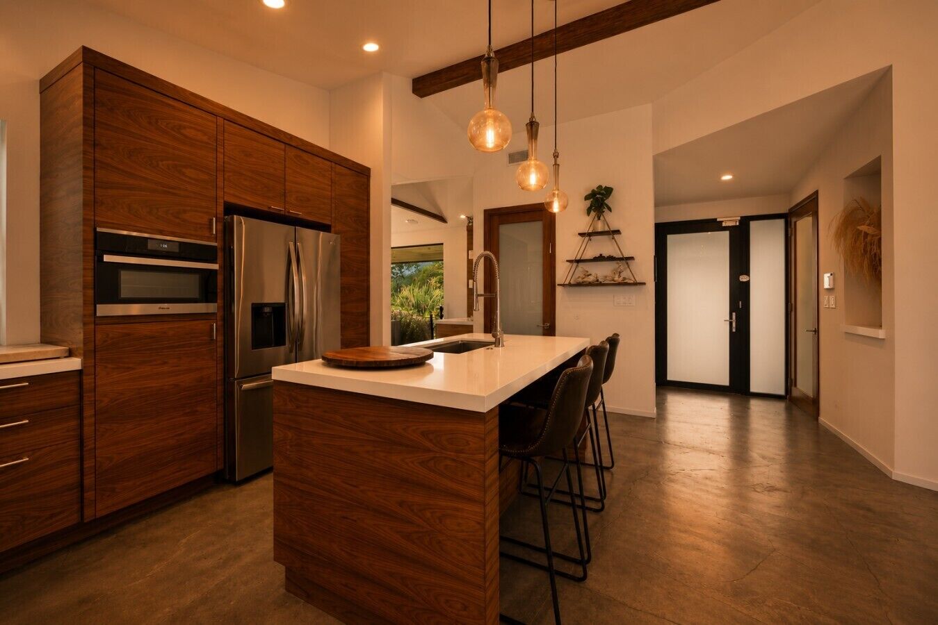 A modern kitchen with wooden cabinets, stainless steel appliances, and a central island with bar stools.