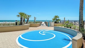 A paved pathway leading to a beach with palm trees and a blue circular design on the ground. - BEACHFRONT, FAMILY FRIENDLY, INDOOR/OUTDOOR POOL & HOT TUB (Orange Beach)