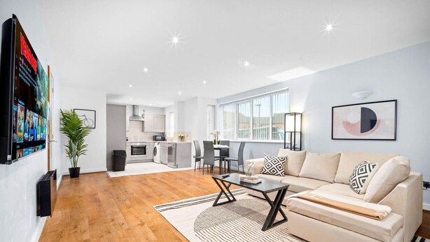 A modern living room with a sofa, coffee table, and a dining area. - Modern 2 Bedroom Apartment - Jewellery Quarter - Pet Friendly (Birmingham)