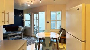 A compact kitchen with a dining area, a built-in oven, and a refrigerator. - Historic Bakery Storefront-Private Yard & Laundry (Albuquerque)