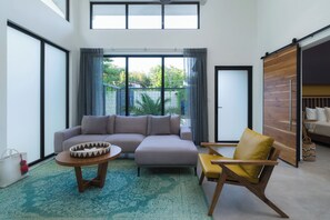 A modern living room with a sectional sofa, a yellow armchair, and a coffee table.