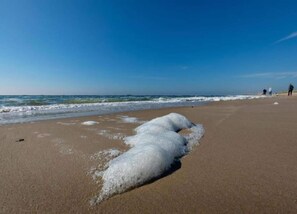 A beach with waves breaking on the shore and a few people in the distance. - Holiday Home Near Dutch Beach and Dunes (Sint Maartensvlotbrug)