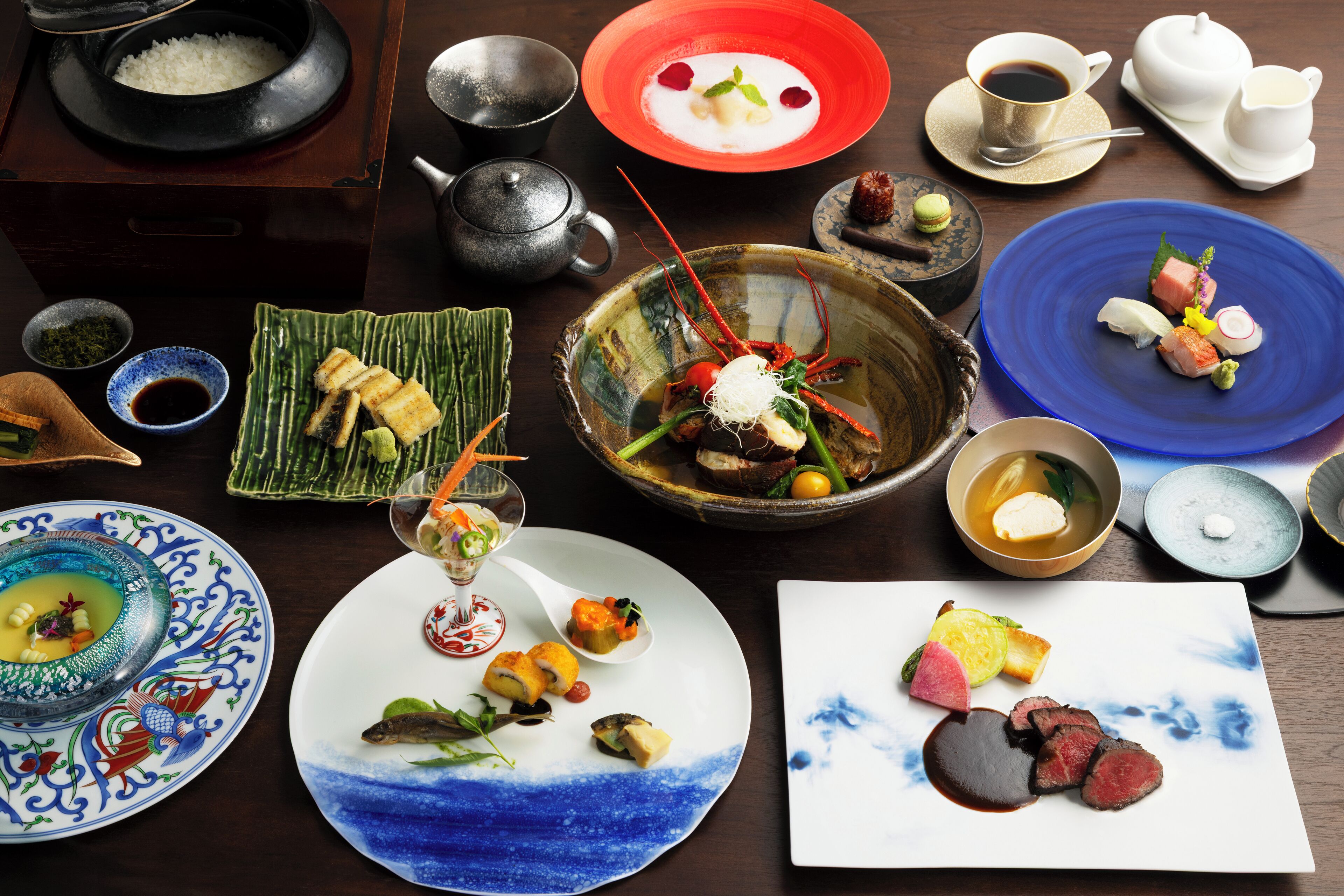 A variety of dishes on a table, including sushi, sashimi, and other Asian cuisine.