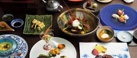 A variety of dishes on a table, including sushi, sashimi, and other Asian cuisine.