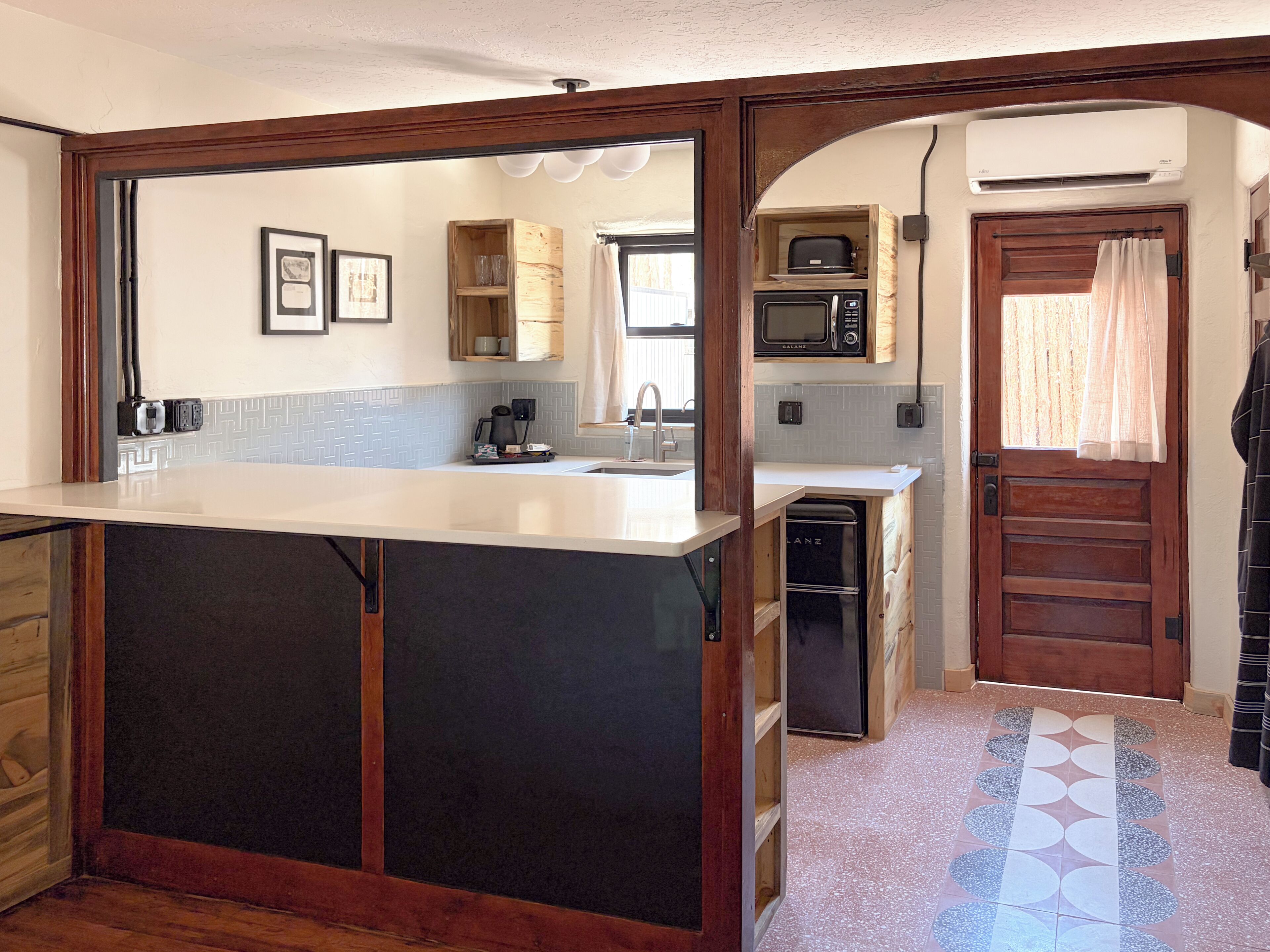 A kitchen with a central island, built-in microwave, and wooden cabinets.