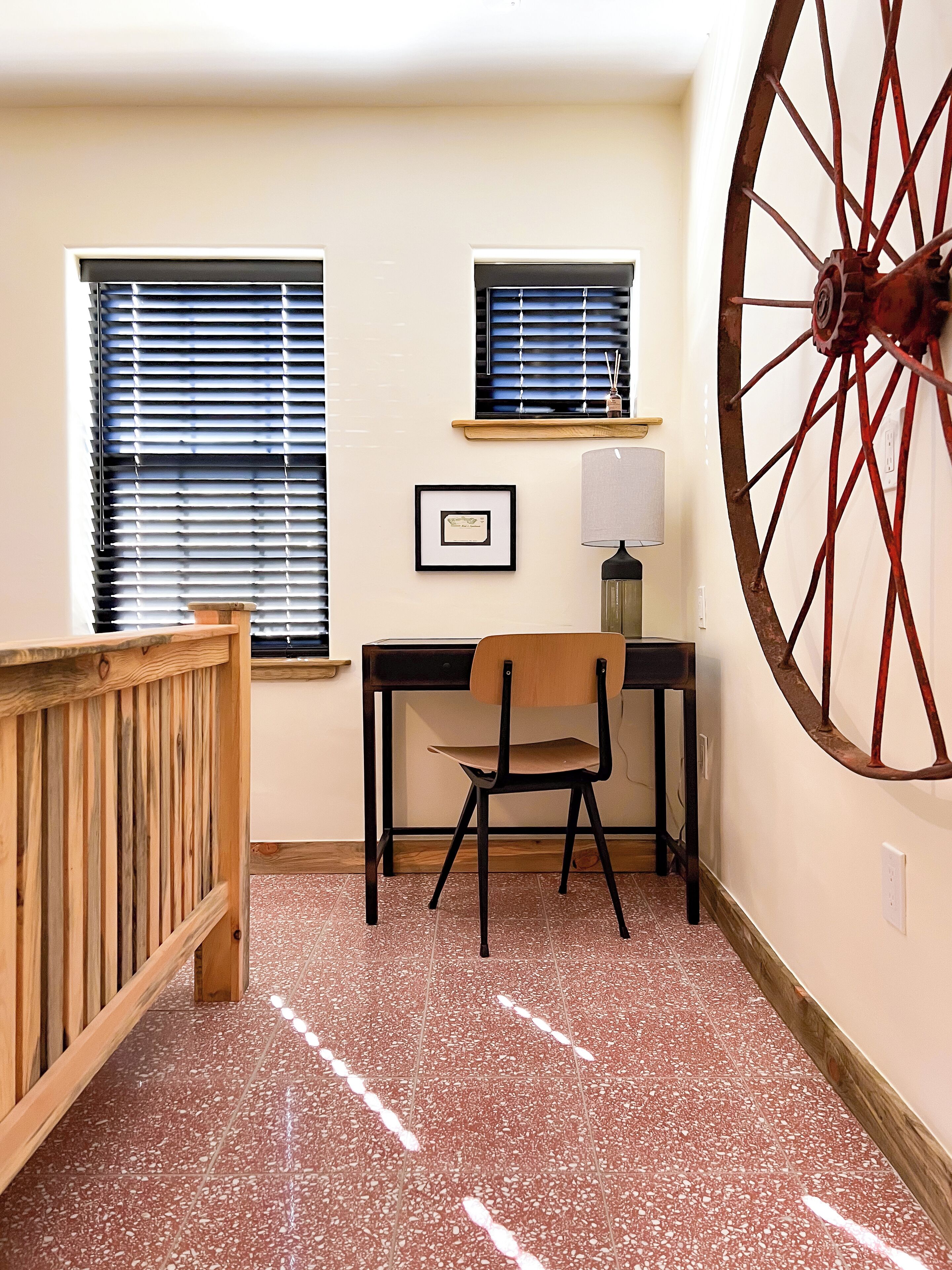Une pièce comprenant un bureau, une chaise et une grande structure circulaire fixée au mur.