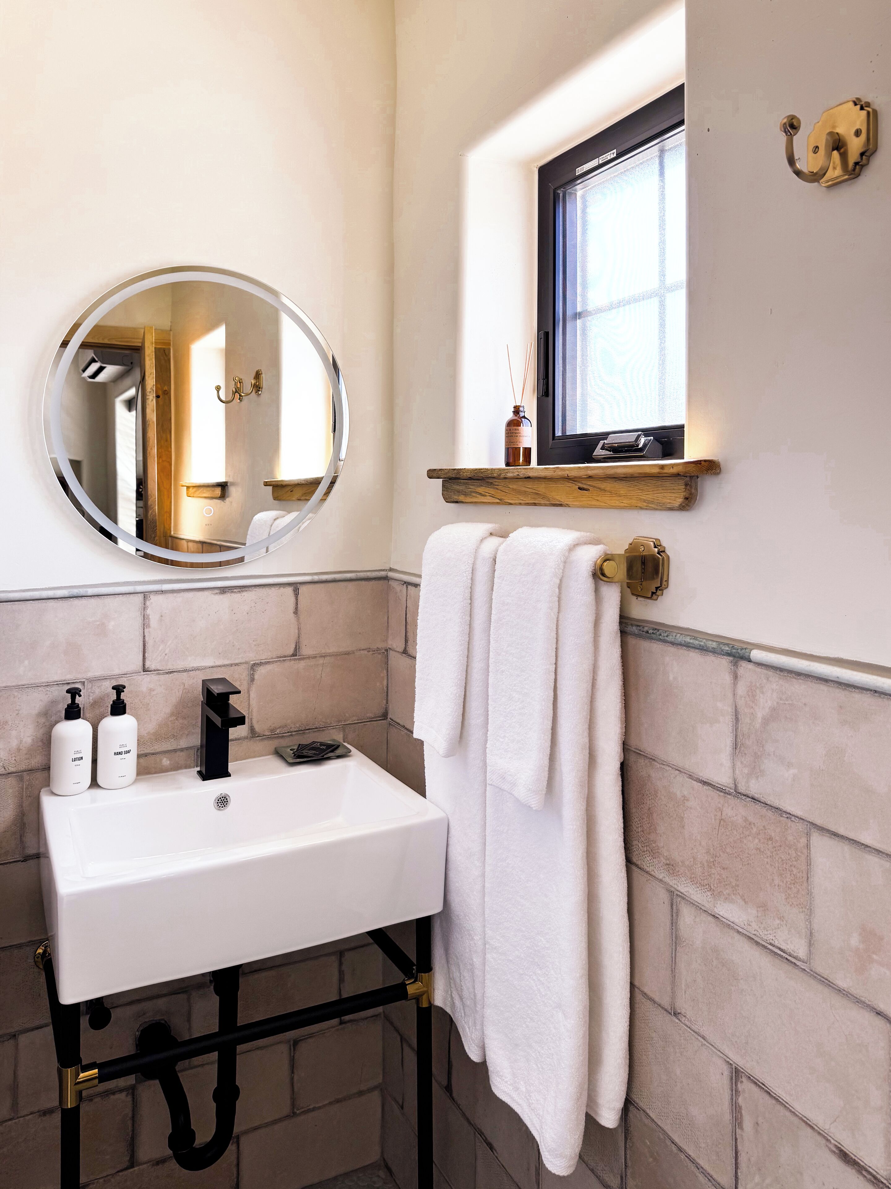A bathroom with a white sink, black faucet, and a towel hanging on a rack.