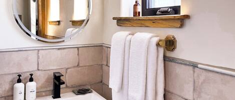 A bathroom with a white sink, black faucet, and a towel hanging on a rack.