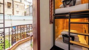 Una habitación con balcón, una cama litera y vistas a la ciudad.