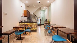 Un interior moderno con una zona de bar, diversas opciones de asientos y una escalera que conduce a otro nivel.