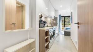 Een moderne keuken met een inbouw wasmachine, een eethoek met uitzicht en een grote spiegel aan de muur.