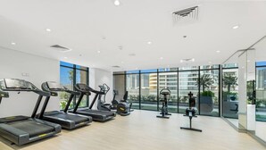 Een moderne sportschool met loopbanden, elliptische trainers en gewichten.