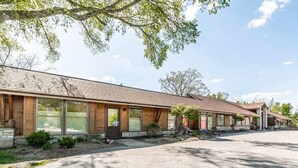 Un bâtiment à deux étages, composé d’une série de pièces, doté de grandes fenêtres et d’une fondation en pierre.