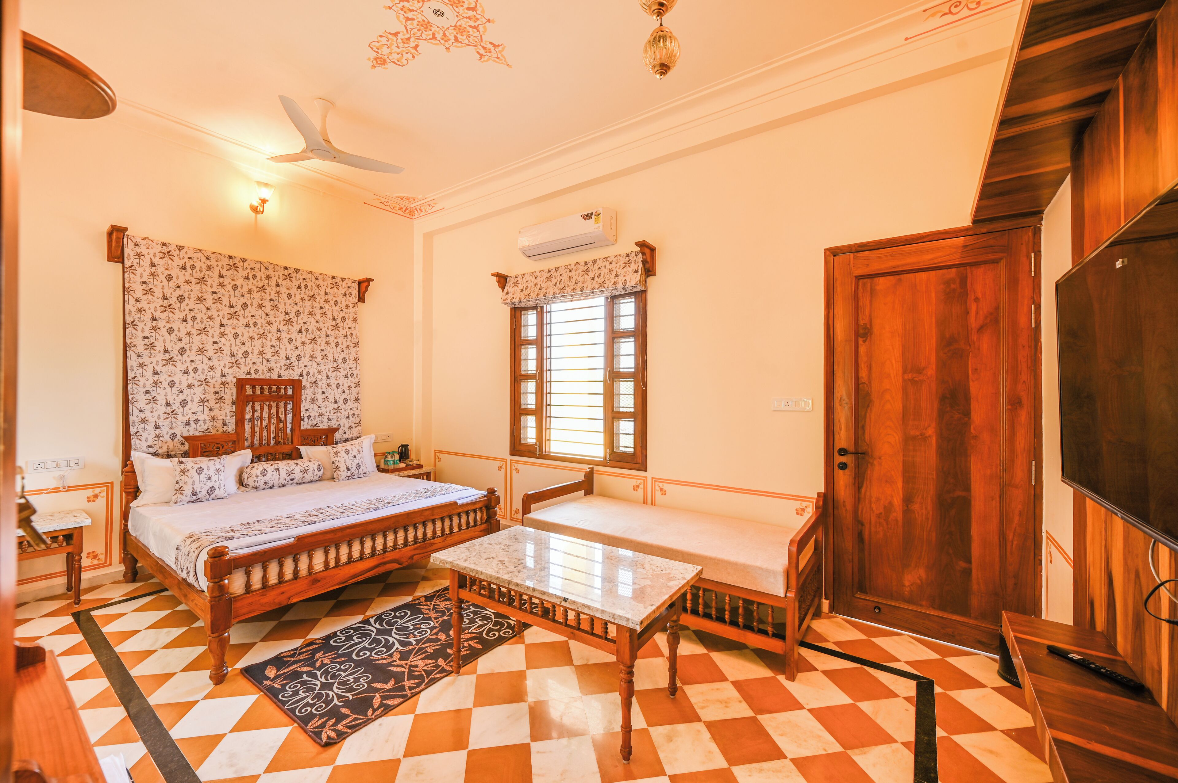 A bedroom with a bed, bedside table, and a window with shutters.