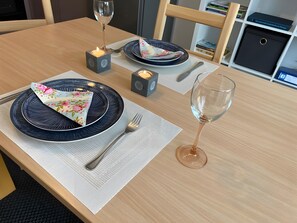 A dining table set with plates, cutlery, a glass of wine, and candles. - Holiday Apartment 'Petit Bijou' with Wi-Fi near Freiburg, Germany, France & Switzerland (March)