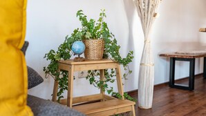 Ein Holzschemel mit einem Globus und einem gewebten Korb mit Grünpflanzen.