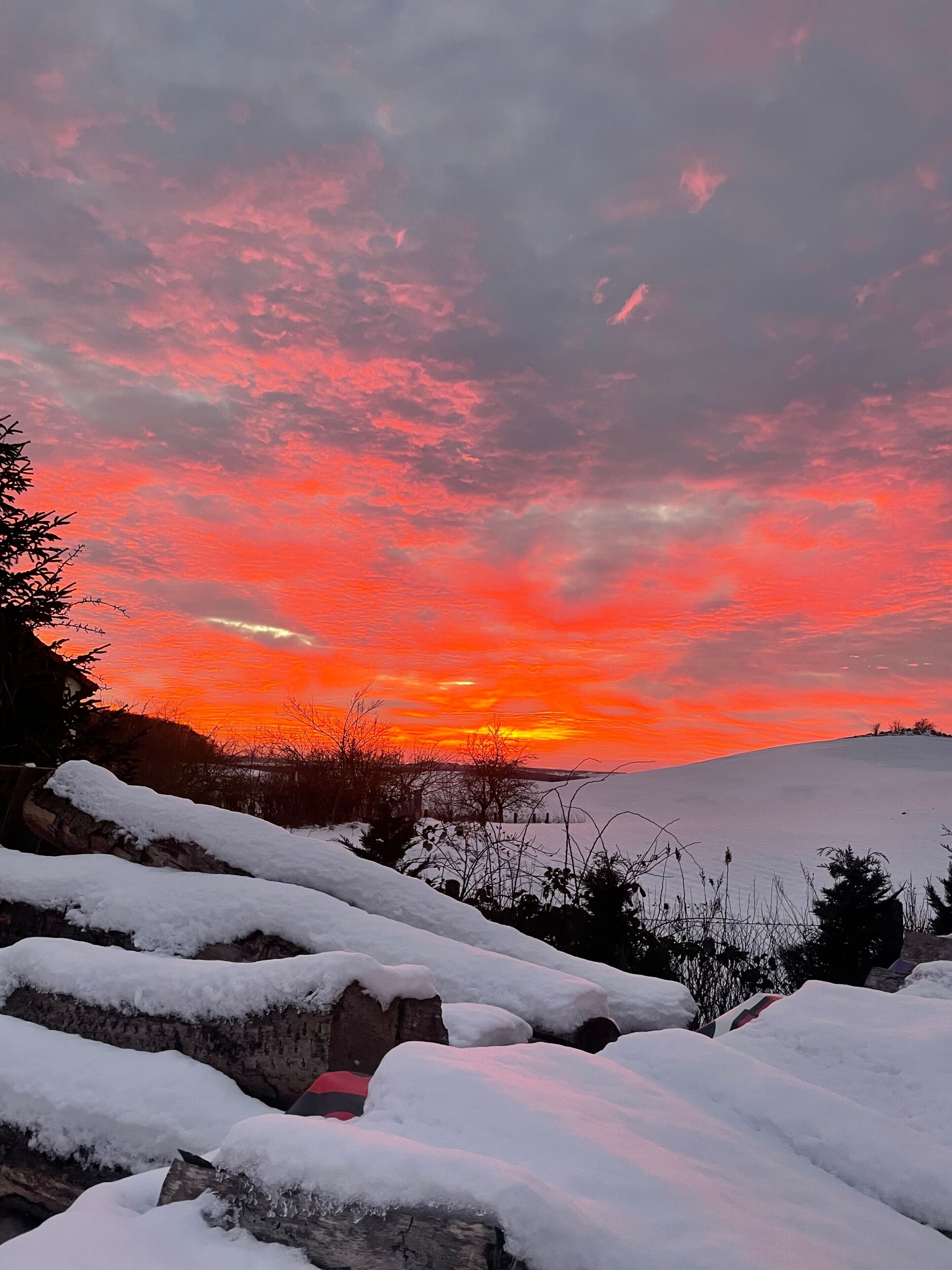 A snowy landscape with a sunset sky.
