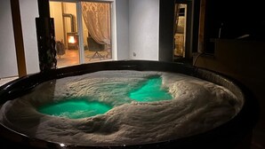 Ein Whirlpool mit Blick auf einen Raum mit Schiebetür und einem Sessel.