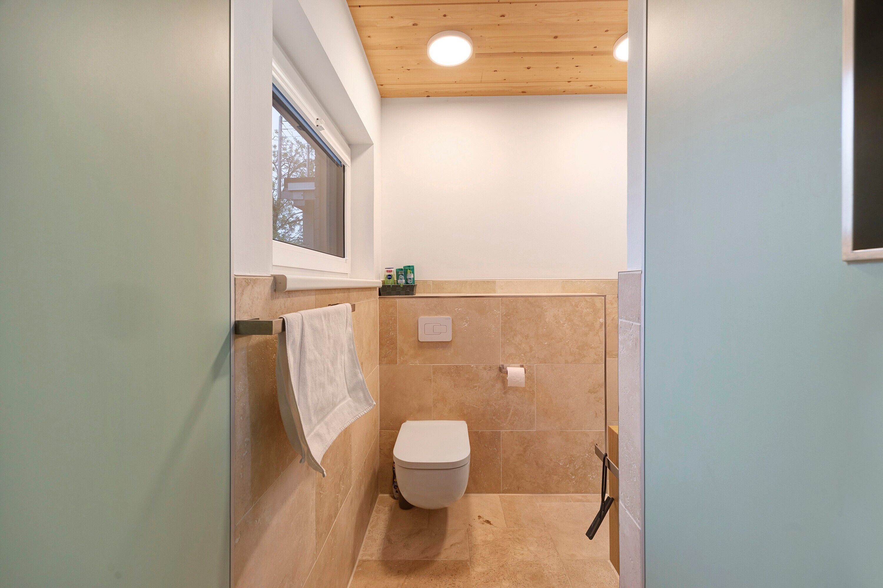 Ein Badezimmer mit Toilette, Dusche und Fenster.
