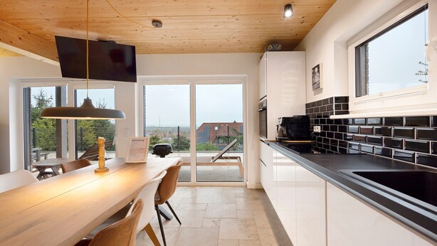 A modern kitchen with a dining area, large windows, and a view of the outside. - Holiday Home 'Mit Panoramablick' with Mountain View, Shared Terrace and Wi-Fi (Gernrode)