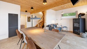 A modern kitchen with a wooden table, chairs, and a built-in stove. - Holiday Home 'Mit Panoramablick' with Mountain View, Shared Terrace and Wi-Fi (Gernrode)