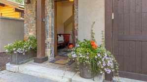 A stone building entrance with a wooden door, numbered 6A, and two flower planters on the steps. - SkiView Luxury Townhome - Steps to Ketchum + Skiing, Dog-Friendly! (Ketchum)