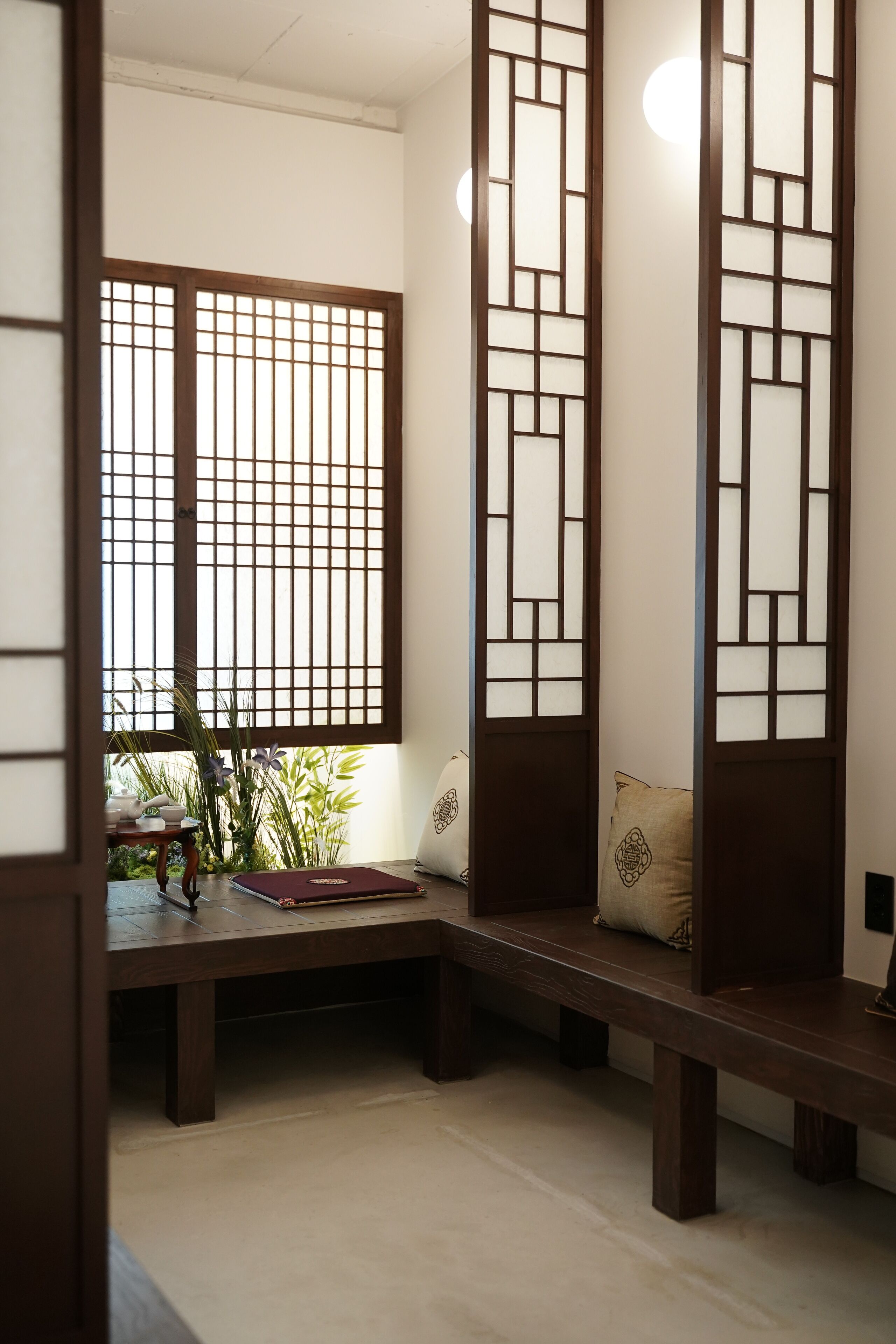 Une pièce de style japonais traditionnel, avec un sol recouvert de tatamis, un banc bas en bois et une porte coulissante de type shoji.