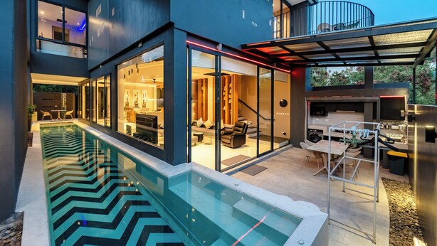 A modern house with a swimming pool, glass doors, and a covered outdoor area. - Beautiful Sea View Full Smart House 3BR (Rawai)