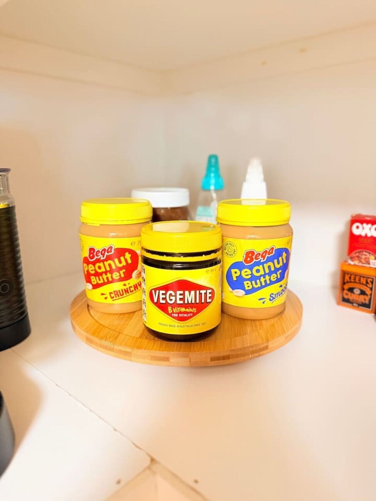 Three jars of Vegemite peanut butter on a wooden board.