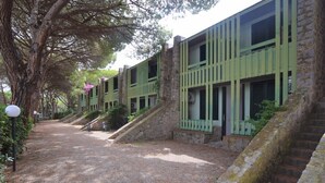A building with multiple windows and a gravel path leading to the entrance.