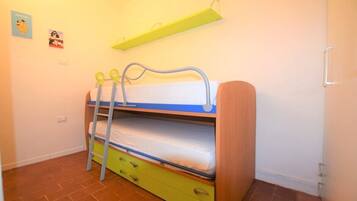 A bunk bed with a green ladder, a white mattress, and a blue headboard.