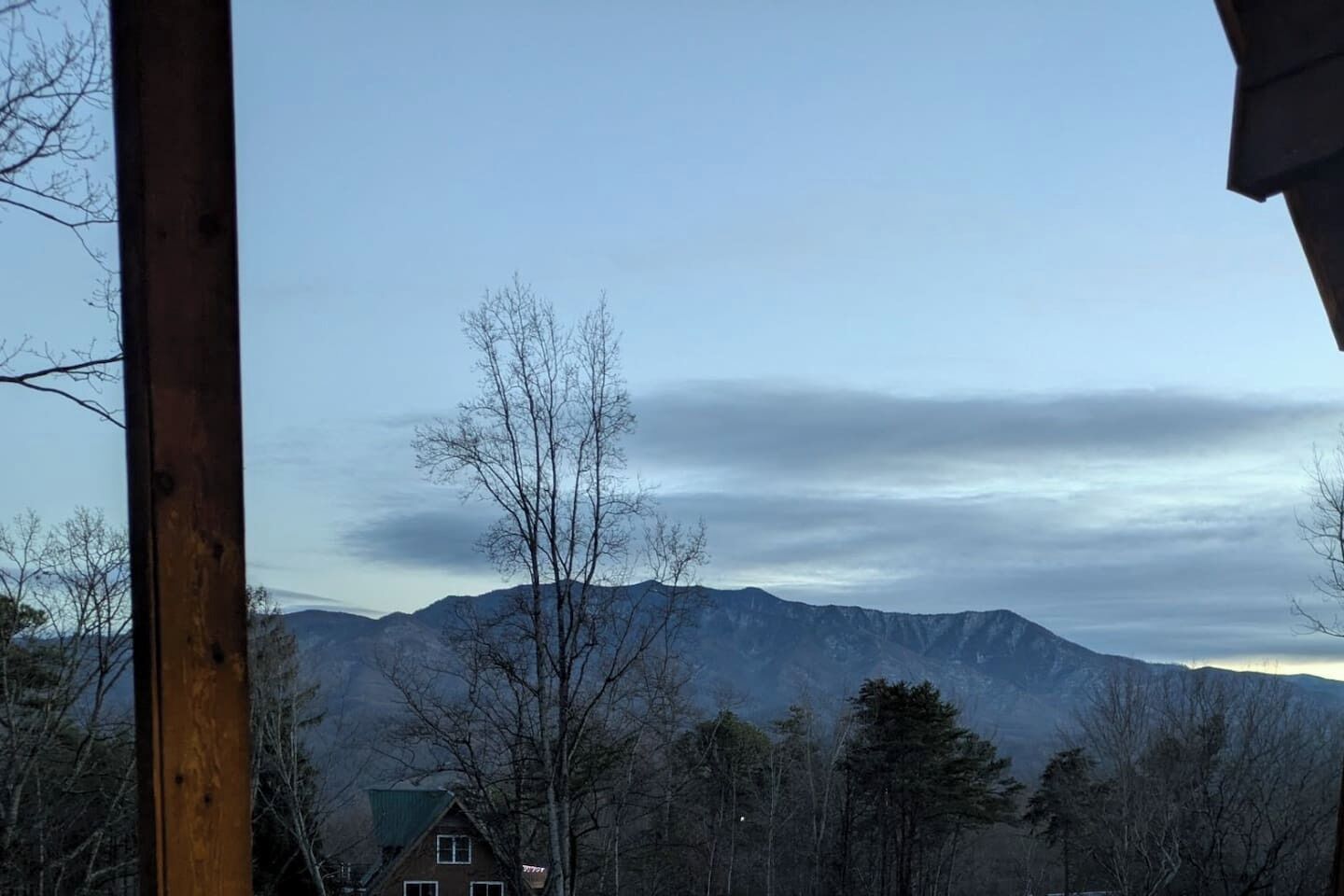 Una cordillera con una casa en primer plano.