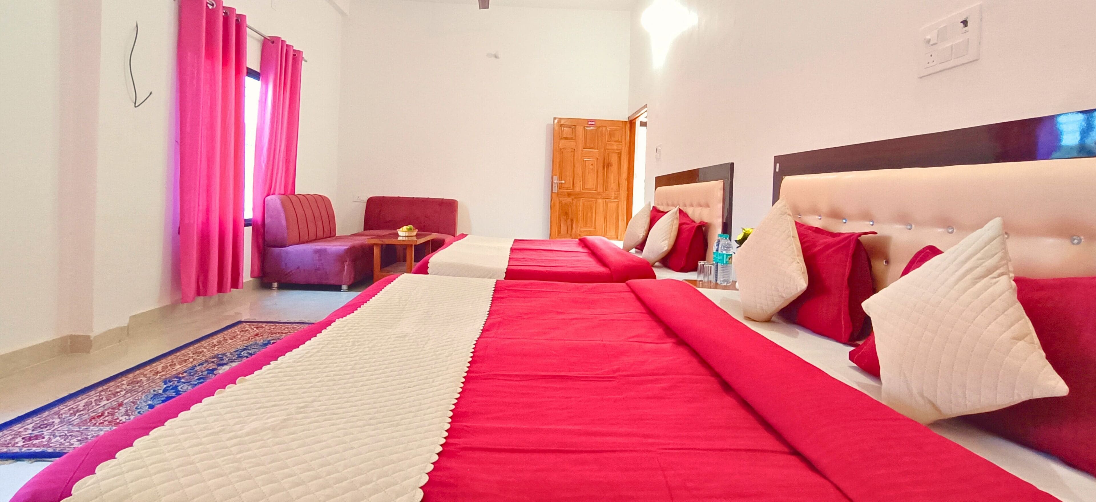 Una habitación de hotel con una cama grande, un sofá, una mesita y una puerta de madera.