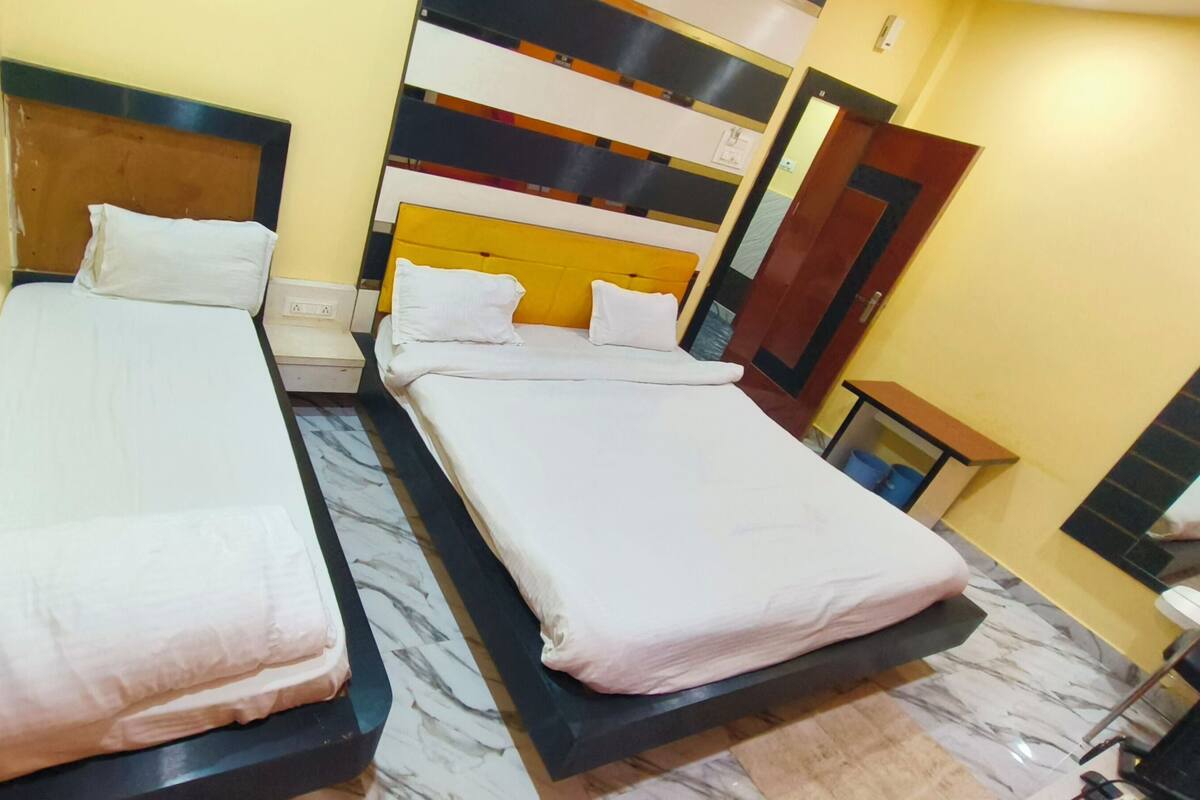 Two single beds with white linens, a marble-patterned floor, and a modern wall design.