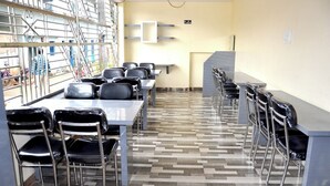 Ein Konferenzraum mit langem Tisch, Stühlen und Deckenventilator.