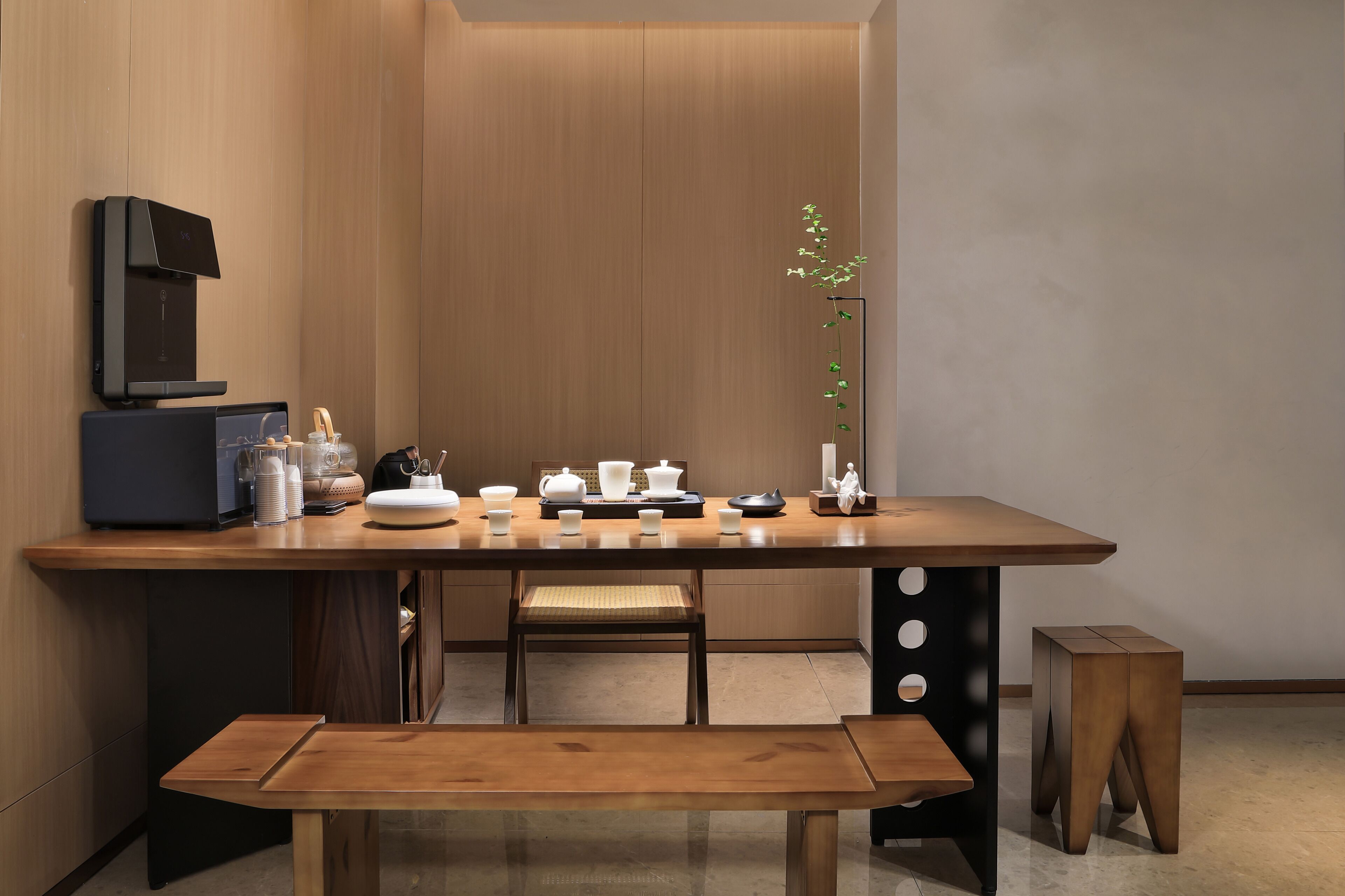 A modern kitchen with a wooden table, a bench, and a coffee machine.