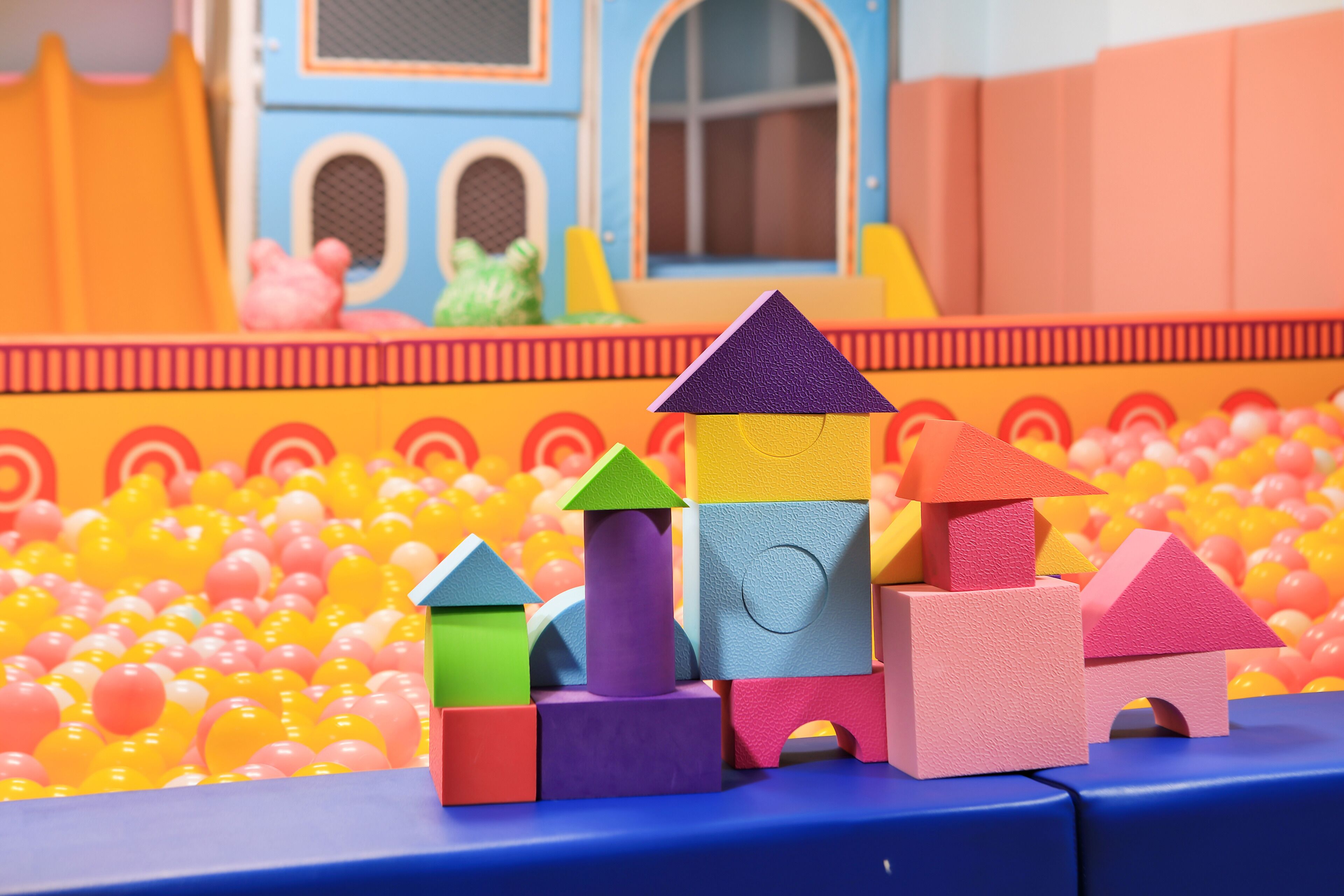 A play area with colorful building blocks and a ball pit.