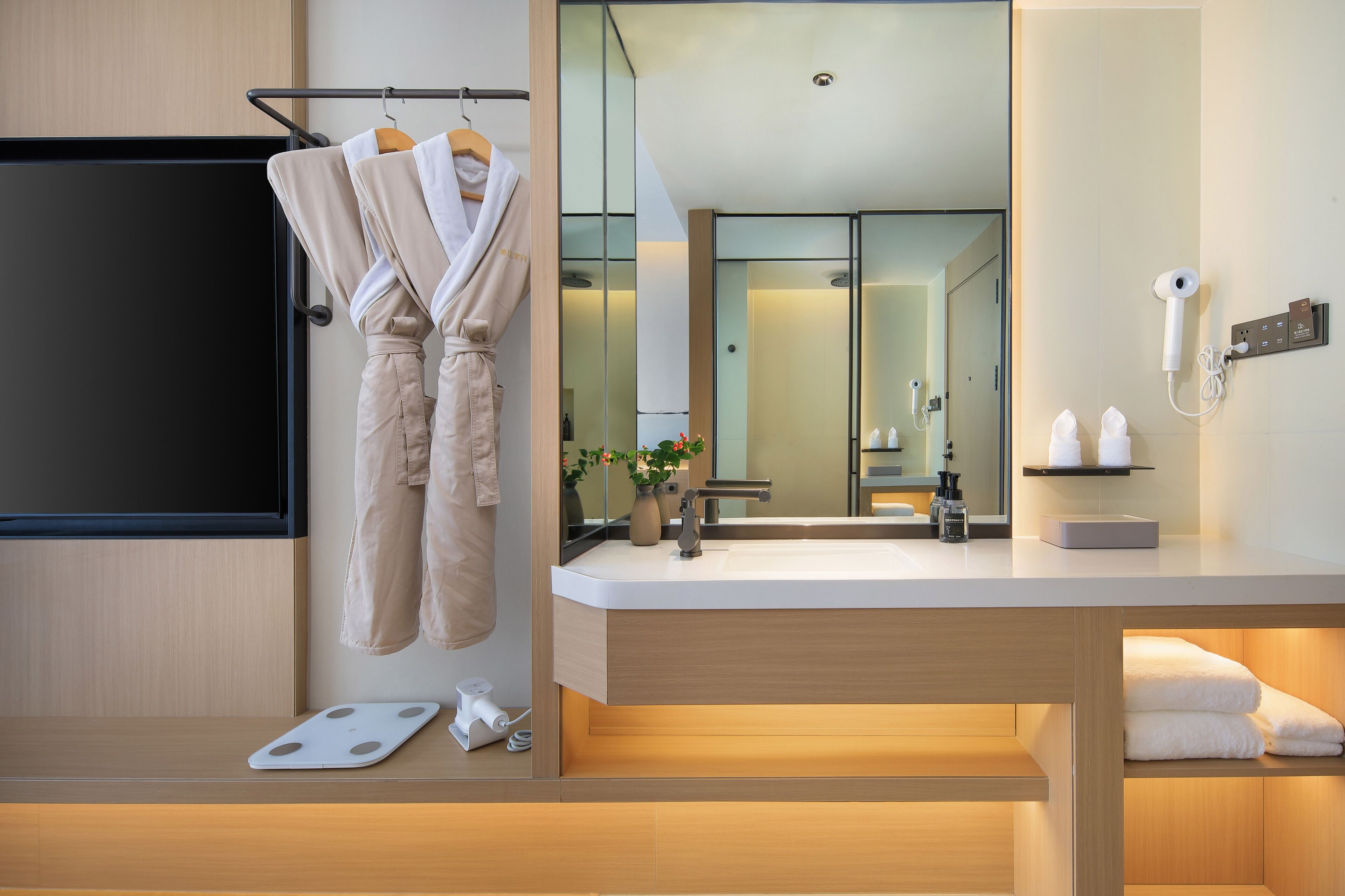 A modern bathroom with a large mirror, a sink, and a towel rack.