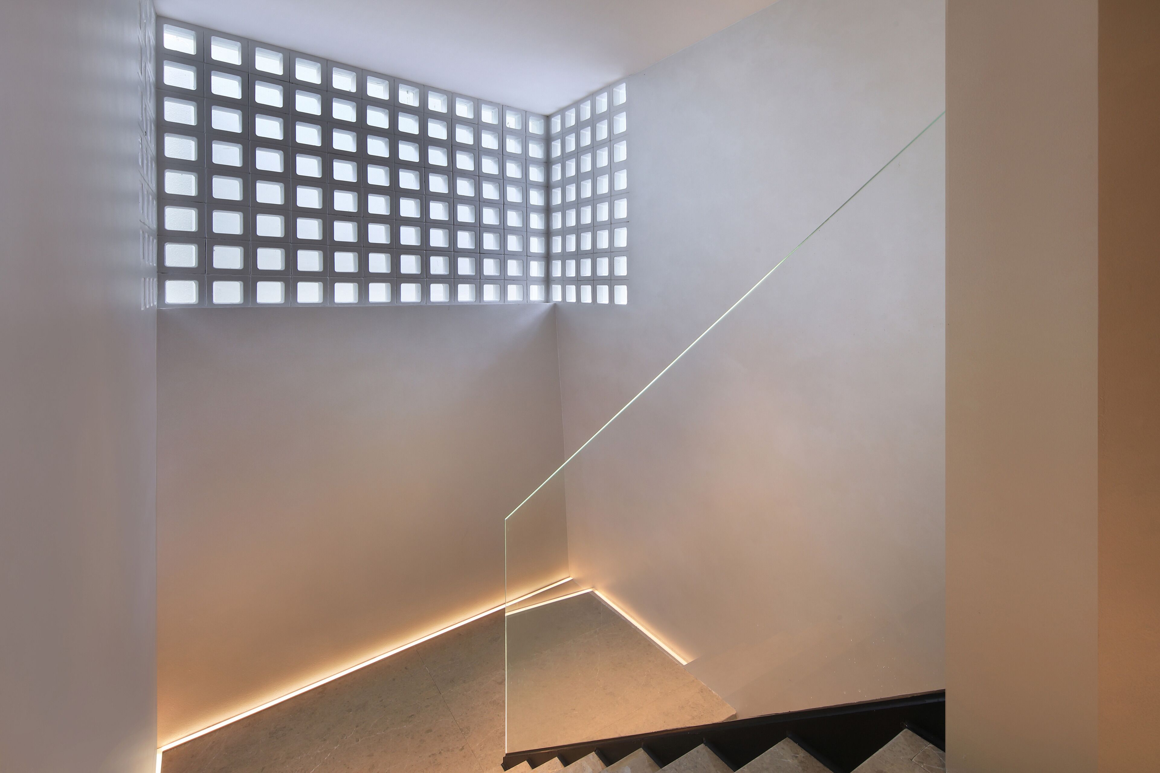 A modern interior with a geometric light fixture and a patterned wall.