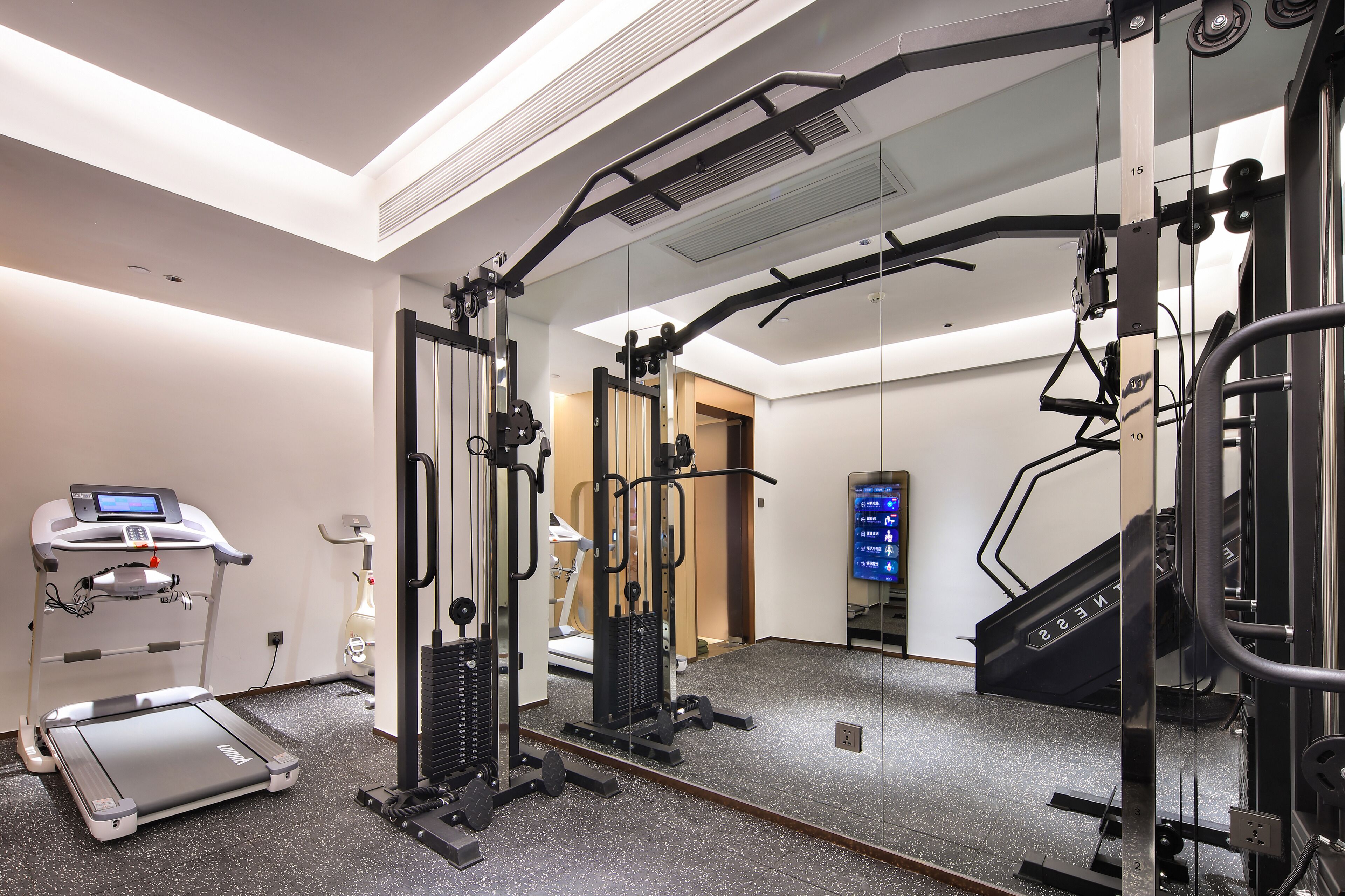Una palestra con tapis roulant, macchinari per pesi e attrezzi per lo step.