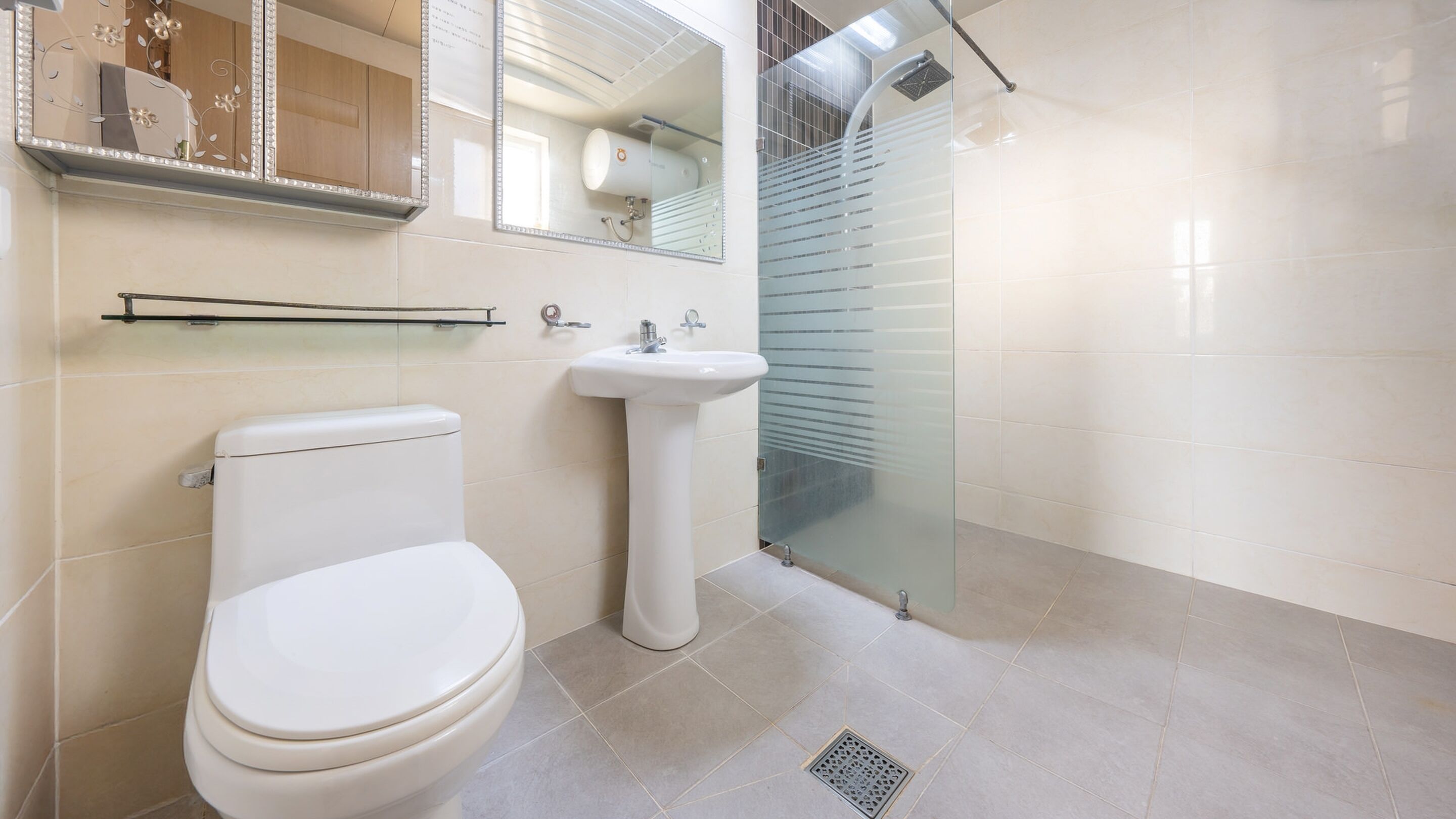 A modern bathroom with a toilet, sink, and glass shower enclosure.