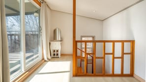 A spacious room with large windows, a wooden floor, and a view of a deck. - Ganghwa Raube Pet-friendly Pension (Incheon)