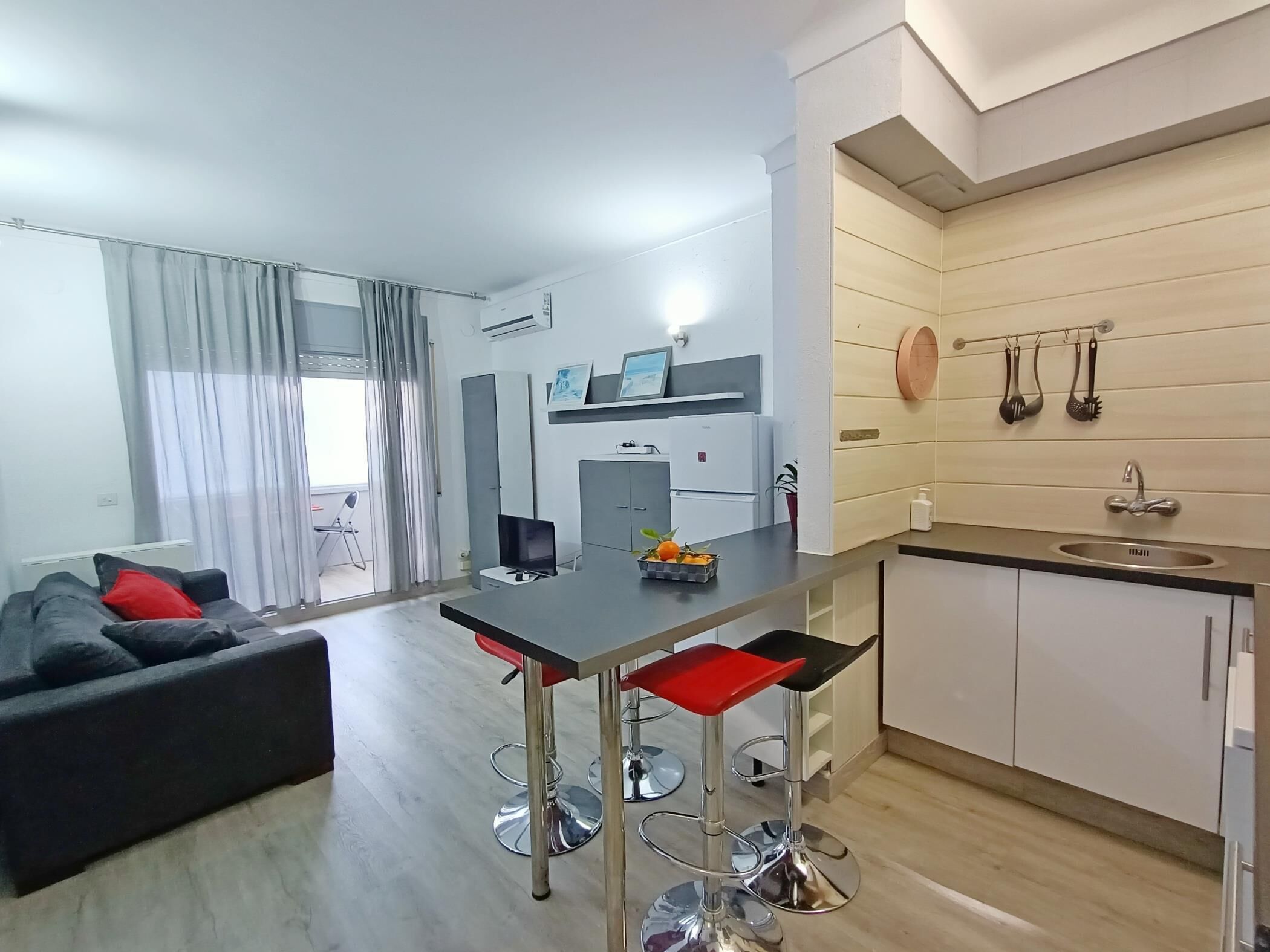 Um apartamento moderno com área de jantar, cozinha e sala de estar.