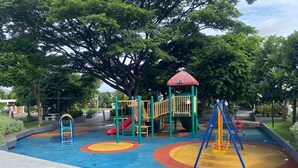 Ein Spielplatz mit Rutschen, Klettergerüsten und einer Schaukel.