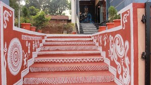 Un escalier orné de motifs blancs complexes menant à l’entrée d’un bâtiment.