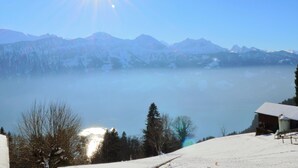 Un paysage de montagne enneigé, avec un ciel dégagé et un soleil brillant.