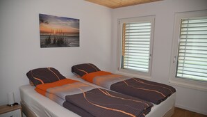 Une chambre à coucher avec un lit, une table de chevet et une fenêtre avec des stores.