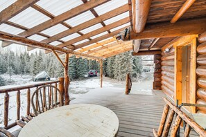A wooden deck with a table and chairs, leading to a cabin with a metal roof and log walls. - 3 Mi to Kenai River: Secluded Sterling Cabin! (Sterling)